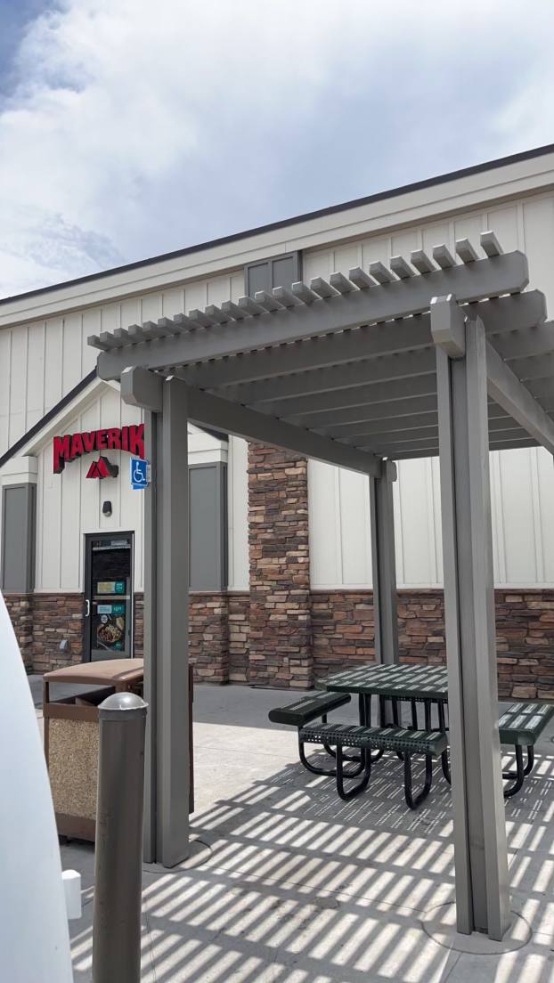 Freshly painted commercial gas station exterior at Maverik, featuring a pergola, picnic table, and clean vertical siding with stone accents — part of our professional Commercial Painting Services.